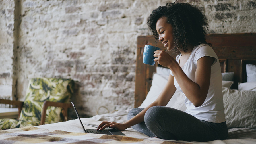 Woman in Bed checking out eStatements on laptop