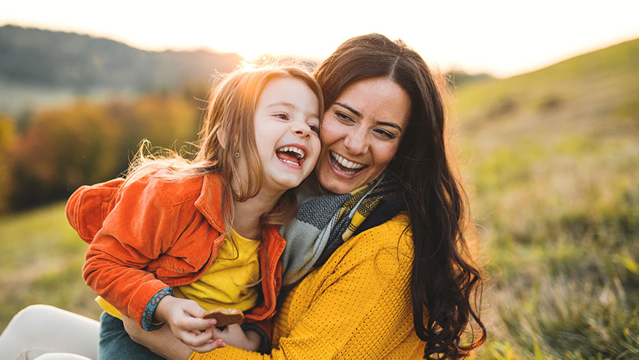 Mother and daughter in a field laughing