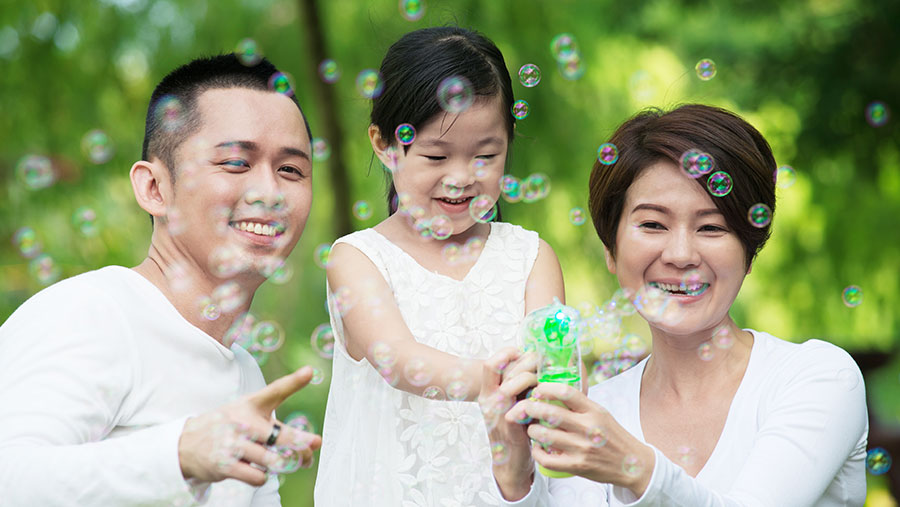 Family playing with bubbles outside