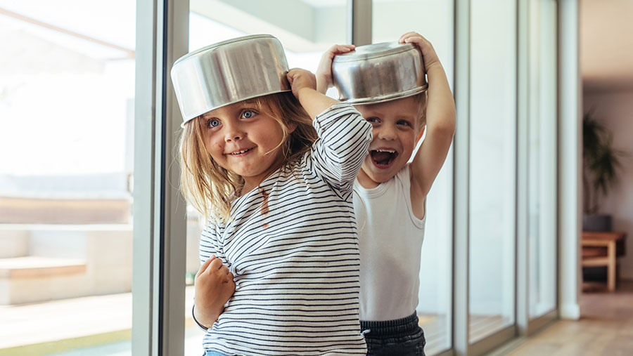 Children playing with pots on their head