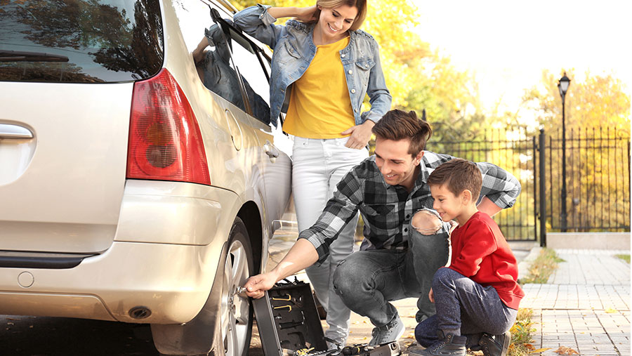 Family pumping air in car tire