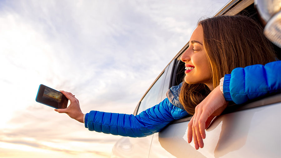 Woman taking picture from car