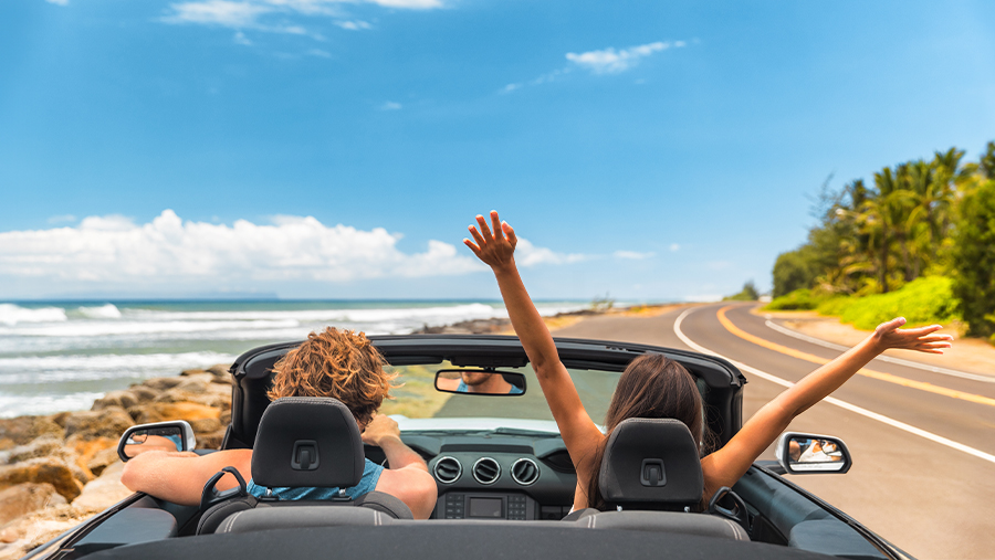 Couple enjoying summer road trip with blue sky and tropical sunny scenery