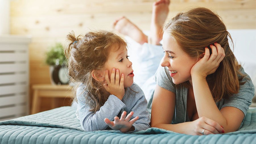 Mother and daughter on bed