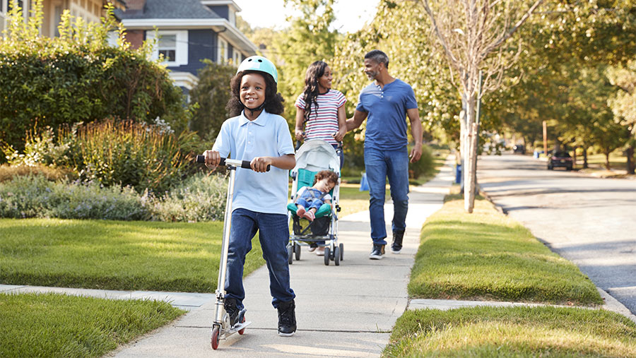 Family on sidewalk enjoying outside activities