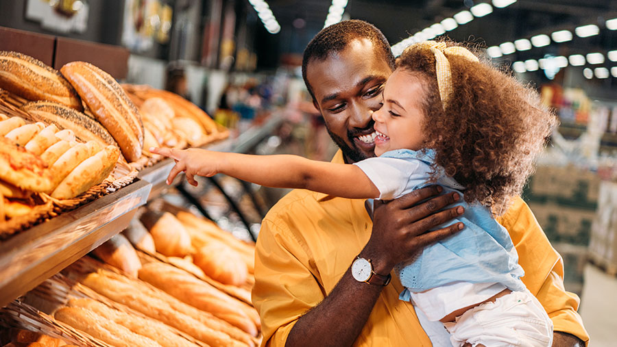 Father and daughter buying bread