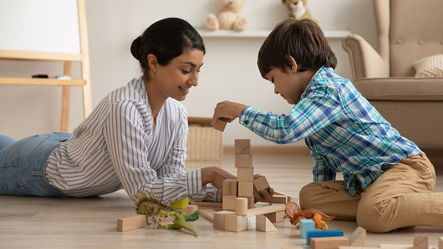 Mother and son playing with blocks at home